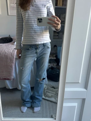 Lågmidjade baggy bootcut jeans - Supersnygga utsvängda jeans med hål från LondonJean i storlek 6. För referens är jag 172 och brukar ha xs/s.🩵🩵🩵 Midjemått rakt över:39cm Innerbenslangd:84.5cm