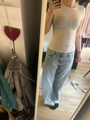 Vit tight t-shirt topp - Säljer en vit, genomskinlig, tight och kortärmad t-shirt topp i ett tunt och stretchigt material. Toppen har en rund halsringning och är figurnära med en ljus ton. Perfekt att styla med jeans eller kjol.