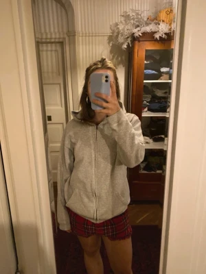 Ljusgrå zip hoodie med huva - Säljer en enkel och skön ljusgrå hoodie med dragkedja och huva. Hoodien har en avslappnad passform och är tillverkad i mjukt sweatshirtmaterial. Perfekt för chill dagar eller när du vill ha något bekvämt att slänga på dig.