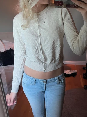 Ljus beige tröja/ kofta - En skrynklig ljusbeige kofta från H&M