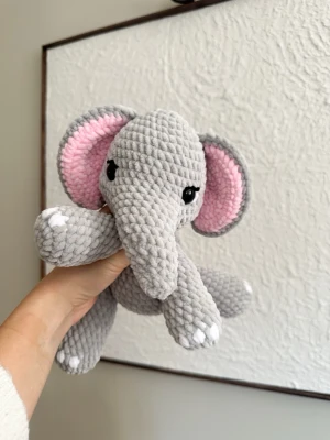 Gosedjur - Handvirkad elefant 🐘 - Virkad elefant i chenillegarn 🐘. Elefanten har svarta säkerhetsögon som sitter fast från insidan. Rekommenderas dock inte för de allra minsta barnen, då det alltid finns en viss risk, vid hårt drag, att de lossnar.   Elefanten är 22cm i höjd.  Perfekt som present eller mysig inredningsdetalj! Tvättråd: max 30°C, handtvätt.