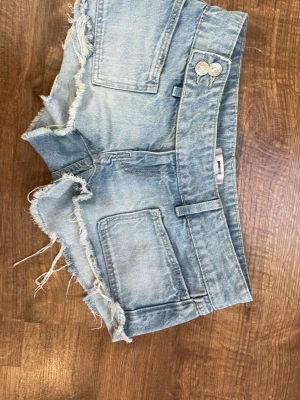Ljusblå jeansshorts från Gina Tricot - Säljer ett par ljusblå jeansshorts från Gina Tricot i storlek XS. Shortsen har råa, fransiga kanter, stora fickor fram och dubbla knappar i midjan. Perfekta för varma dagar och ger en avslappnad vibe. De är i storlek xs men passar också s, De är andvända bara 2 gånger och jag säljer de för att jag ej gillade färgen på dem 😁 Dem har inga defekter alls och är som nya. dem är också tvättade och fräscha. orginell Priset är 300kr men jag säljer de för 265 för jag har bara andvänt dem få gånger