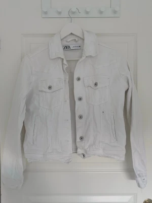 Vit jeansjacka från Zara - En vit jeansjacka från Zara. Bifogade även att det finns svart färg på jackan 