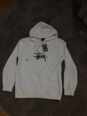Stussy hoodie - Vit stussy hoodie – Storlek S(passar xs✅ – tag kvar, men kvitto saknas 💸 Helt oanvänd – inga märken, fläckar eller skador 📦 Originalpåse saknas, men skickas väl emballerad ⚠️ Säljes p.g.a. fel storlek 📍 Möts upp i Göteborg eller skickas spårbart  Skicka ett meddelande om du är intresserad eller har frågor!
