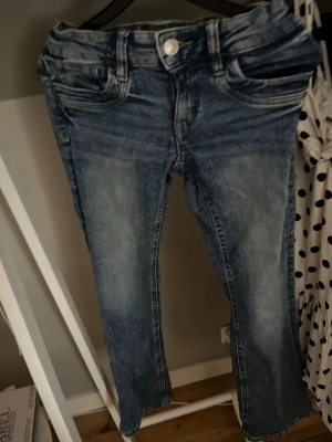 Blå jeans - Säljer ett par blå jeans. Jeansen har klassisk femficksmodell, knapp och dragkedja framtill samt tydliga sömmar. Perfekta till en avslappnad stil och passar till det mesta i garderoben.
