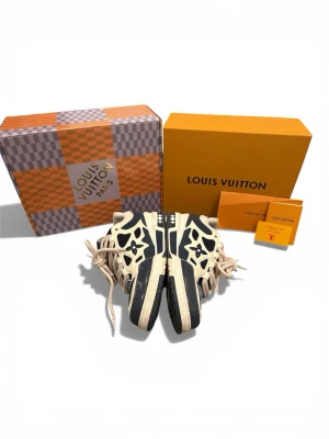 Louis Vuitton Navy size 44 - Snygga Louis Vuitton sneakers i navy med unika LV-detaljer och blommönster på sidorna. Skorna har chunky beige snörning, meshpaneler och robust sula. Perfekta för dig som vill sticka ut med exklusiv streetstyle.