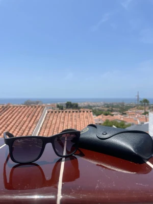Svarta Ray-Ban Justinas - Ray-ban Justins just nu är de påväg att bli för små så det är dags att sälja de. De är i barn modell men passar nån upp till 15 år gammal. De är inköpta i en återförsäljare i ett köpcentrum kvitto finns inte med. Väldigt fint ljus i de med en lila till blå ton.