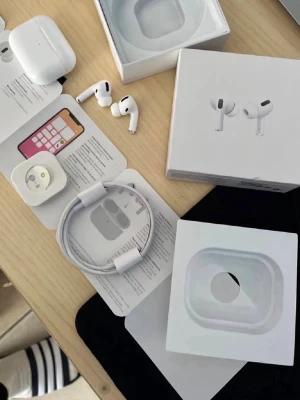 Apple AirPods Pro trådlösa hörlurar - Säljer ett par vita Apple AirPods Pro med laddningsetui, extra silikonpluggar och laddningskabel. Hörlurarna har en stilren och kompakt design med korta stjälkar och mjuka in-ear-tips för bekväm passform. Perfekt för dig som vill ha grymt ljud och smidig anslutning.