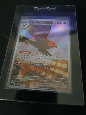 Pokémonkort Talonflame holo - Säljer ett Pokémonkort med Talonflame-motiv. Kortet är holografiskt och har färger i rött, brunt och gult. Det ligger i ett genomskinligt plastskydd. Kortet har attackerna Sky Hunt och Fire Wing och är från Sword & Shield-serien.