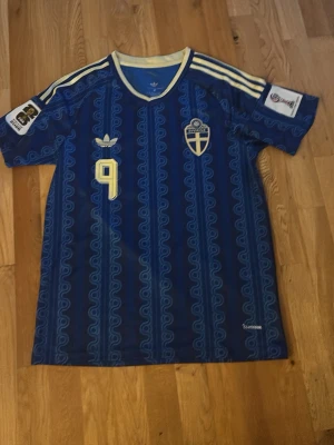 Sverige landslagströja-Isak#9 - Säljer en Sverige landslagströja med Isak #9 på ryggen. Tröjan är i mycket fint skick och har VM 2026-märke på ärmen, se bilder. Inte använt den och det är storlek M som passar helt utmärkt.