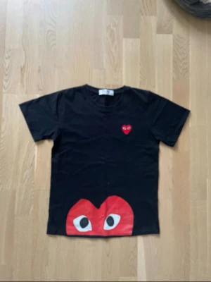 Comme des garçons T- shirt - Säljer detta svart och röd comme garcöns t shirt på gott skick, har bara använt den 5 gånger. Storlek S passa xs också. Bra genuin kvalitet. Skicka bra prisförslag som är inte för lågt så accepterar jag direkt.. 
