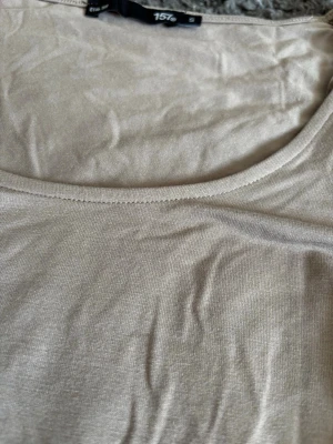 Beige linnetopp från 157 - Säljer en enkel och stilren beige linnetopp från 157. Toppen har rund halsringning och ärmlös design, perfekt för varma dagar eller som lager under en skjorta. Tillverkad i mjukt material som känns skönt mot huden. Har nästan onte använt den