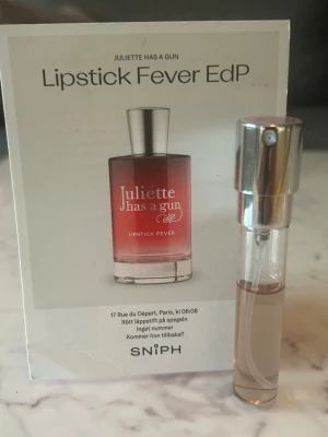 Juliette Has A Gun Lipstick Fever EdP - En provflaska av parfymen Lipstick Fever EdP från Juliette Has A Gun. Doften kommer i en liten genomskinlig glasflaska med silverfärgad spraykork. Parfymen har en modern och trendig känsla med inspiration från röda läppstift.
