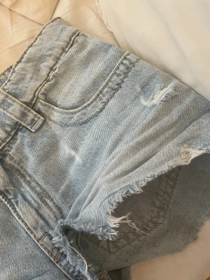 Ljusblå jeansshorts med slitningar - Säljer ett par ljusblå jeansshorts. Knappt använda, säljer för att dom var förstora. Pris kan diskuteras 