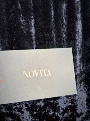 Svarta lackloafers från Novita - Stilrena svarta kostym skor från Novita i glansigt lackmaterial. Skorna har klassisk form med rundad tå och dekorativa snören framtill. Perfekta för dig som vill ha en dressad look med en modern touch.