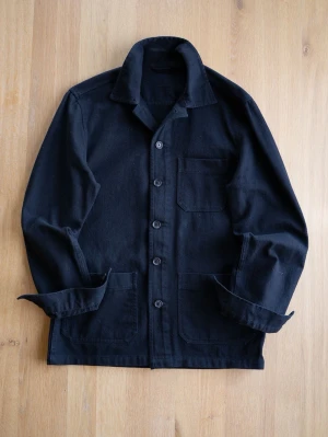 Svart overshirt med fickor - Stilren svart overshirt i kraftigt bomullstyg med klassisk krage och knäppning framtill. Tre praktiska fickor, varav en bröstficka och två större framtill. Perfekt lager på lager-plagg för en avslappnad look.