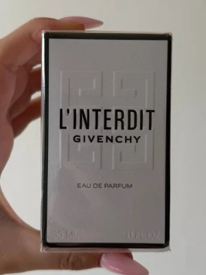 Givenchy L'Interdit Eau de Parfum 35 ml - Givenchy L'Interdit Eau de Parfum är en elegant parfym i en stilren vit och svart förpackning. Doften är intensiv och modern, perfekt för dig som vill ha något klassiskt men ändå vågat. Flaskan är rektangulär och materialet är glas, förpackad i kartong.