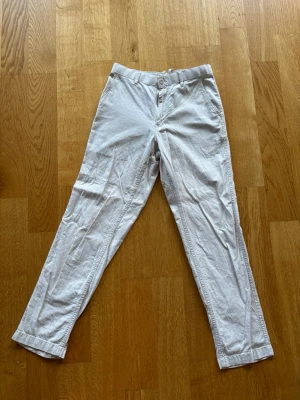 Vita raka linnebyxor - Snygga beigea linnebyxor från uniqlo med rak passform. Perfekta för en avslappnad och stilren look under varmare dagar.
