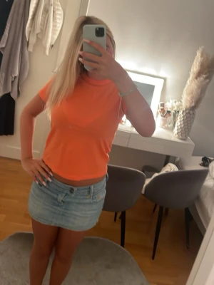Orange croppad t-shirt - Säljer en snygg orange croppad t-shirt med korta ärmar och rund hals. Perfekt till jeans eller kjol för en fräsch och färgstark look. Materialet känns mjukt och skönt mot huden. Storleken är 134/140 men passar mig som brukar ha xs/s