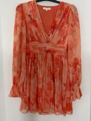Orange miniklänning med volanger och markerad midja - Nypris 499kr. Orange miniklänning med volanger och markerad midja. Aldrig använd med hann ta bort lappen.