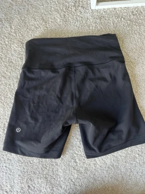 Shorts från Lululemon - Säljer ett par jättefina träningsshorts från Lululemon. Lappen har tyvärr åkt av där bak men är väldigt säker på att de är i storlek 6. Alltså passar de 34/36 beroende på hur man vill att dem ska sitta. (Obs på bilden ser man shortsen bakifrån för att man ska kunna se märket). Skriv om ni har frågor eller vill se fler bilder🥰 