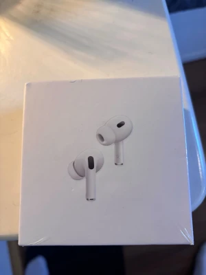 Apple AirPods Pro 2 USB-C - Säljer ett par Apple AirPods Pro (2nd generation) med MagSafe-laddningsetui och USB-C. Hörlurarna är vita, trådlösa in-ear-modell med silikonproppar och stilren design. Perfekta för musik, samtal och brusreducering. Levereras i originalförpackning.