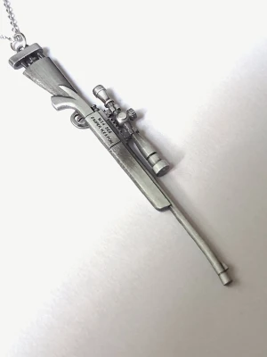 Silvrigt halsband med M24 SWS prickskyttegevär - Silvrigt halsband med ett M24 SWS prickskyttegevär. Det är graverat med texten "M24 SWS SNIPER WEAPON" på sidan av lådan. Materialet rostfritt stål. 