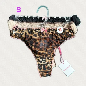 3-pack lätt genomskinliga Juicy Couture stringtrosor i S - • 3-pack lätt genomskinliga Juicy Couture stringtrosor i 3 färger och mönster.  • En leopardmönstrad stringtrosa med texten ”Juicy” samt  en svart med texten ”Be Mine” & en beige med texten ”Wild Babe”….tror jag det står. • Finns även i M.