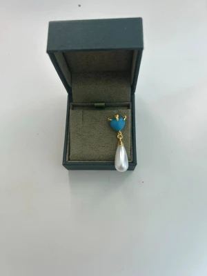 Maria Nilsdotter örhänge - Säljer mitt jätte snygga örhängen med blå topp och hängande vit pärla från Maria Nilsdotter! Är väldigt sparsamt använt och är ca 4500kr nypris. Kom gärna med prisförslag. Finns också inte längre kvar på hemsidan. Perfekt till dig som gillar något unikt❣️