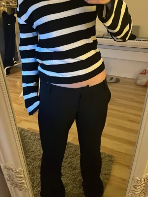 Svartvit randig croppad topp - Säljer en svart och vit randig croppad topp med lång ärm och loose passform. Toppen har breda horisontella ränder och är perfekt för en trendig och avslappnad stil. Pris kan ändras