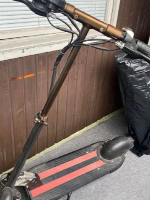 Svart elscooter från Liviae - Elektrisk scooter i svart med röda detaljer på fotplattan. Utrustad med digital display och flera knappar på styret. Scootern har robust ram och bred fotplatta för stabil körning. Perfekt för smidig transport i stan. Åker 45km/h och 45km räckvidd