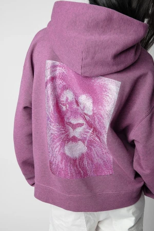 Lila hoodie med lejonmotiv - Cool lila hoodie med stor huva och ett glittrigt lejonmotiv i rosa och vitt på ryggen. Oversized passform och mjukt material, perfekt för en avslappnad streetstyle-look. Snygg detalj som sticker ut och ger en unik vibe till outfiten. Några paljetter på lejonet saknas, men syns nästan inte