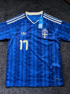 Sveriges bortatröja VM 2026 - Säljer en blå Sverige fotbollströja från Adidas med nummer 17  Gyökeres på ryggen. Climacool-material för bra ventilation. Tröjan är slutsåld överallt. Köpt på Adidas för 1100kr.