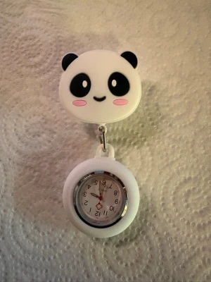 Söt panda fob watch i vitt - En gullig fob watch med vit silikonram och ett clip i form av ett pandahuvud med svarta öron och rosa kinder. Perfekt att fästa på kläder eller väska. Urtavlan är vit med tydliga siffror och sekundvisare.