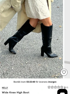Svarta knähöga boots från Nelly - Stilrena svarta knähöga boots från Nelly med bred passform och kraftig klack. Skorna har spetsig tå och är tillverkade i ett glansigt material som ger en trendig look. Perfekta för att lyfta vilken outfit som helst.