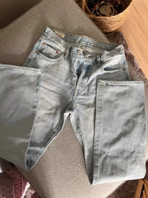 Ljusblå 501s Levi's jeans  - Säljer ett par klassiska ljusblå 501 Levi's jeans med raka ben och hög midja. Jeansen har knappgylf, fickor och tydliga sömmar. Tillverkade i slitstark denim som ger en avslappnad och tidlös look. Köpta förra åren men knappt använt dem då dem är förstora💕