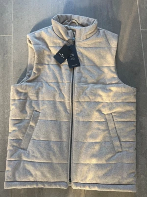  Beige tunn  dunväst med dragkedja - Stilren beige dunväst från John Henric Flannel Zip Vest. Helt oanvänd.