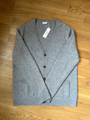 John Henric cardigan - (Helt ny) Klassisk kofta från John Henric med v-ringning och fyra svarta knappar framtill. Blanding av merinoull och bomull. Perfekt för lager på lager och enkel att matcha. Nypris 1299