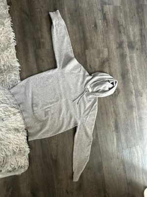 Ljusgrå cashmere hoodie med huva - En stilren ljusgrå hoodie med huva och långa ärmar. Klassisk passform och ribbade muddar vid ärmslut och nederkant. Perfekt för en avslappnad look. Tillverkad i mjukt material för extra komfort.
