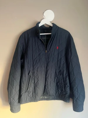 Ralph Lauren jacka - Mörkblå jacka från Ralph Lauren, bra skick överlag men fattas en knapp på baksidan, se bild