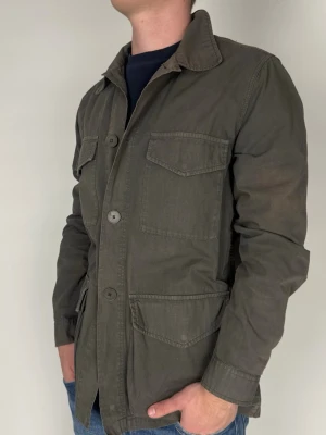 A Day’s March Overshirt - Storlek M passar L  Färg: Olivgrön  Nypris: ca 1500 kr  Skick: Bra med mindre defekter (Lite Solblekt)  Prisvärt alternativ med mycket kvar att ge