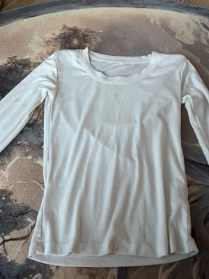 Vit långärmad topp från Dazy - En basic vit långärmad topp från Dazy med rund halsringning. Tillverkad i mjukt och stretchigt material som passar perfekt till lager-på-lager eller som den är. Enkel och stilren design som funkar till många olika looks.