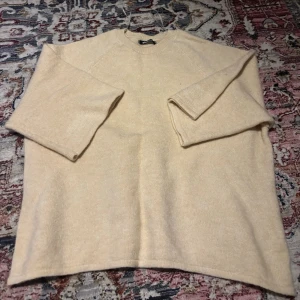 Beige stickad tröja Gina Tricot - Mysig beige stickad tröja från Gina Tricot med rund halsringning och trekvartsärmar. Tröjan har en enkel och avslappnad passform!!