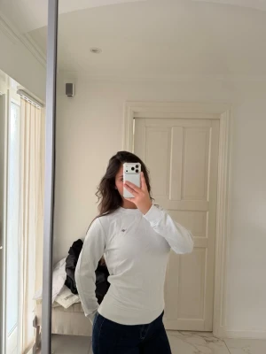 Vit långärmad topp från gant - Säljer en vit långärmad topp från Gantmed liten logga på bröstet. Toppen har en rund halsringning och är i en slim passform, perfekt att styla med jeans eller kjol. Materialet känns mjukt och skönt mot huden.