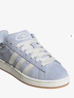 Adidas Campus ljusblå sneakers - Snygga Adidas Campus sneakers i ljusblå mocka med klassiska vita ränder och vit sula. Skon har en låg profil och gummisula med retrovibbar. Perfekt för dig som gillar stilrena och tidlösa sneakers med streetkänsla.