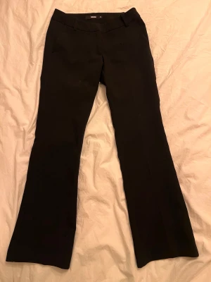 Svarta kostymbyxor från Bik Bok - Snygga svarta kostymbyxor från Bik Bok med klassisk rak passform och pressveck. Byxorna har hällor för skärp och diskreta fickor. Perfekta för en stilren look och passar till många olika outfits.