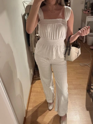 Vit smockad topp  - Vit/off-white smockad topp från Kappahl. Fyrkantig urringning, breda band och markerad midja som ger en jättefin passform. Lätt och luftigt. aldrig använt den!