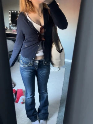 Mörkblå cardigan från Holly & White - Mörkblå, tunnstickad cardigan från Holly & White med små guldiga knappar framtill