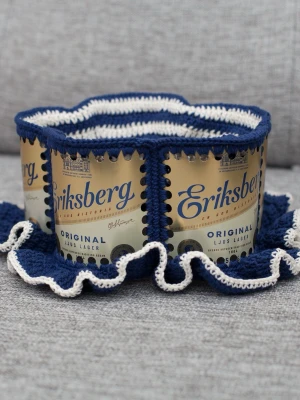 Virkad ölhatt Eriksberg - Unik virkad ölhatt med Eriksberg.  Virkad i 100% bomull. Passar upp till 56cm.  Vissa burkar kan ha mindre repor eller bucklor, vilket tyvärr kan uppstå under tillverkningen av hattarna. Insidan av burkarna slipas efter hålen tagits för att undvika vassa kanter. Därför kan det ibland finnas lite slipmärken, men det är inget som stör eftersom det är på insidan av hattarna.  Färger kan variera något beroende på skärminställningar.