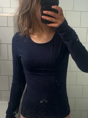 Mörkblå långärmad topp - En enkel och stilren mörkblå långärmad topp med rund halsringning. Toppen har en tight passform och är perfekt att matcha med jeans eller kjol. Tillverkad i mjukt material som känns skönt mot huden. säljer den för den inte kommer till användning. skriv om du har frågor 💕